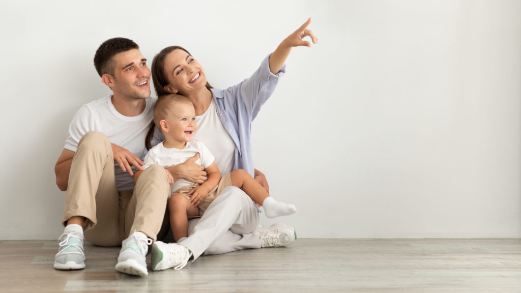 Important Ways To Protect Yourself and Your Family 1 Happy Young Family With Infant Baby Sitting On Floor And Pointing Aside